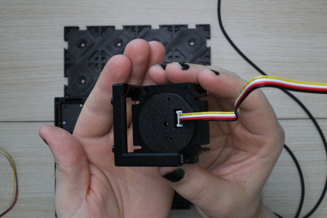 Stelle den Lichtsensor in eine Würfelhälfte, mit dem Kabel gegenüber der Seite mit den Noppen.