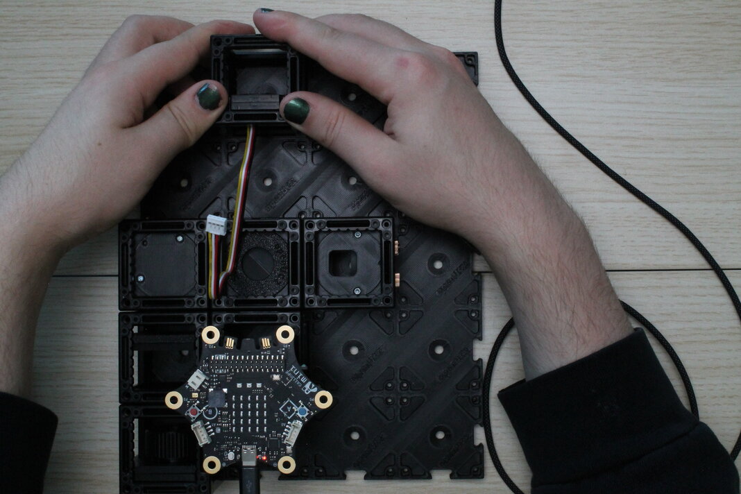 Drücke den Sensorwürfel an der Stelle in die Basisplatte, wo der Schirm war.